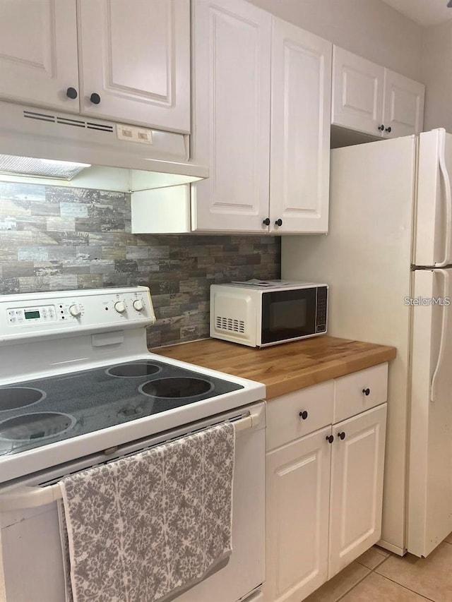 kitchen with white cabinets, light tile patterned flooring, white range with electric cooktop, butcher block counters, and decorative backsplash