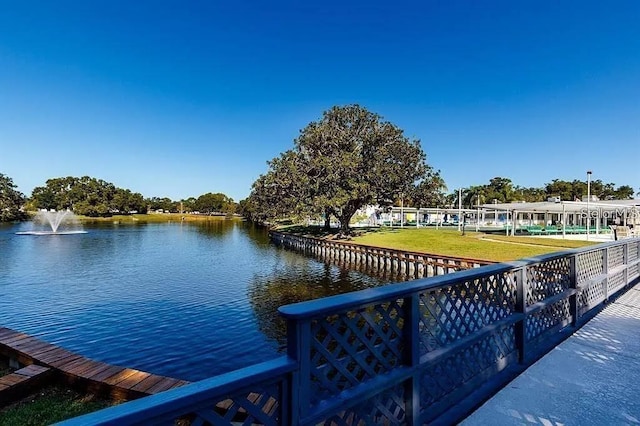 dock area with a water view and a lawn