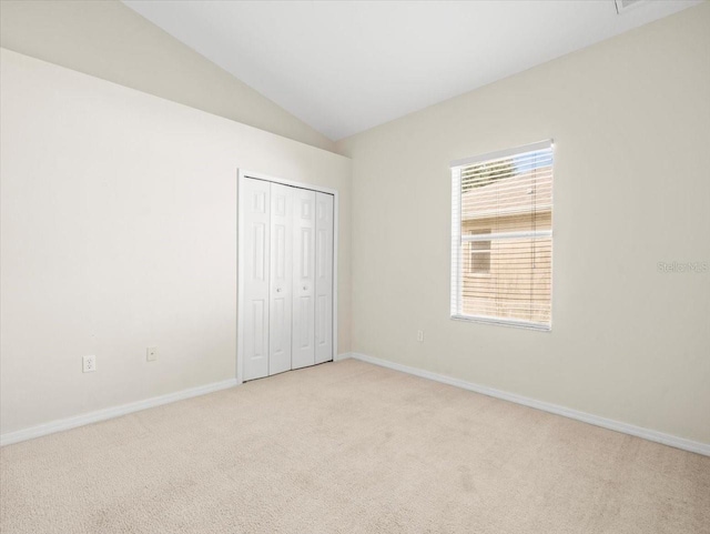 4264 Braemere Dr, Spring Hill, FL 34609 - unfurnished bedroom with light carpet, baseboards, vaulted ceiling, and a closet