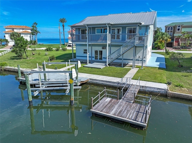 dock area with a lawn, a patio area, and a deck with water view