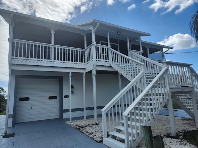 back of house featuring a porch and a garage