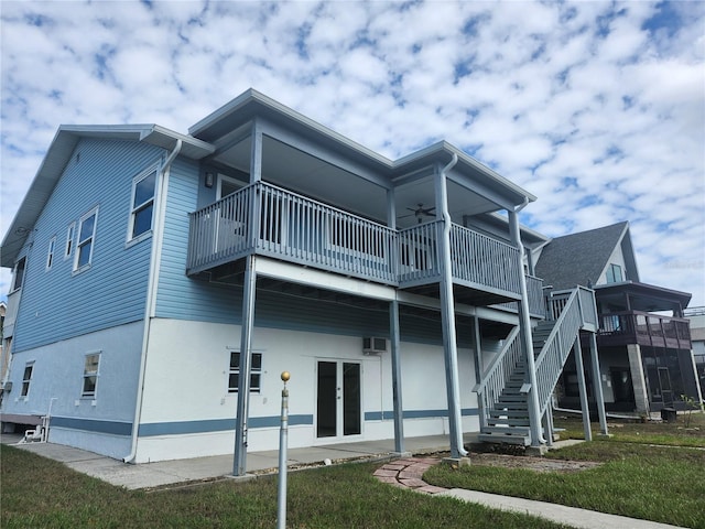 rear view of property featuring a yard, a wall mounted air conditioner, and a deck