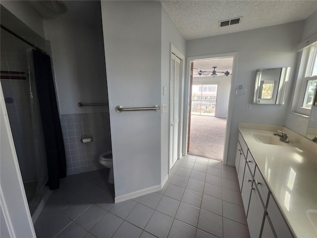 bathroom with vanity, toilet, a textured ceiling, walk in shower, and tile patterned flooring