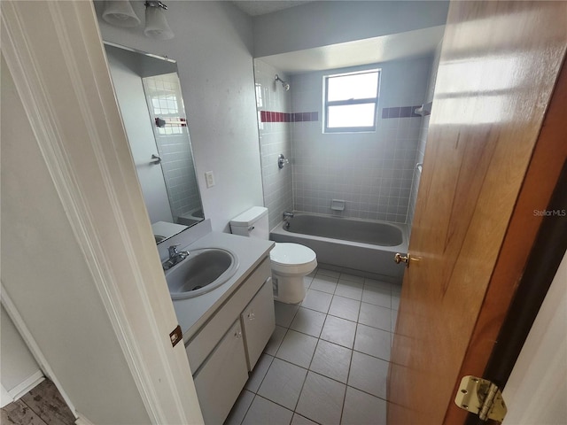 full bathroom with tile patterned flooring, tiled shower / bath combo, vanity, and toilet