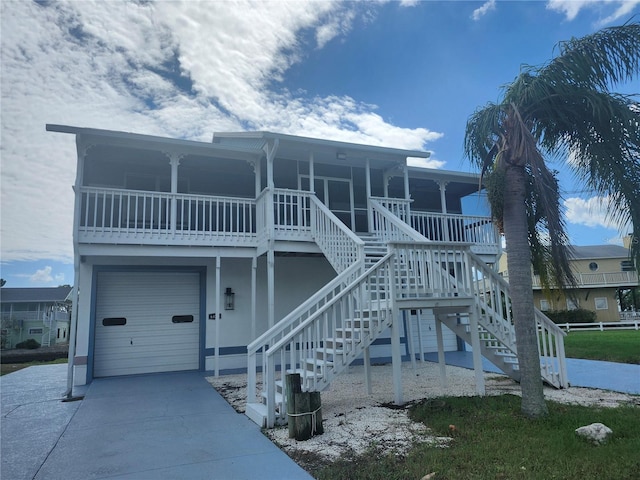 view of front of house with an attached garage, stairs, and concrete driveway