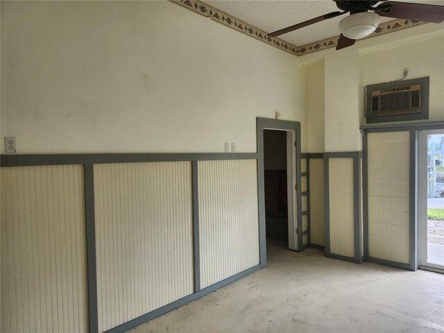 unfurnished room featuring a ceiling fan, a wall mounted AC, and unfinished concrete floors