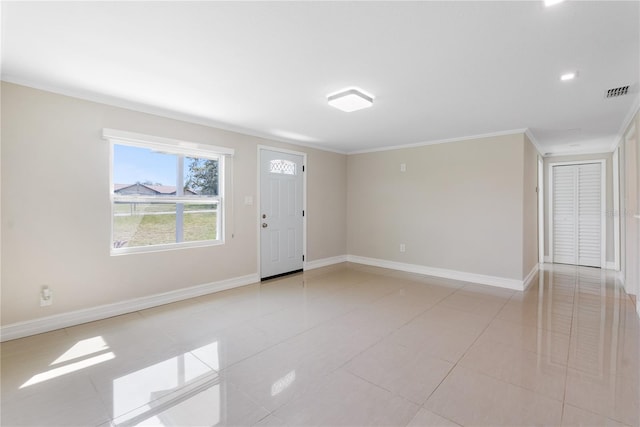 spare room featuring ornamental molding and light tile patterned floors