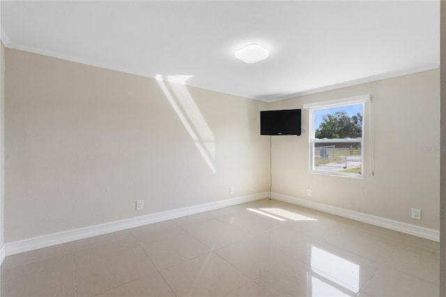 tiled spare room featuring ornamental molding