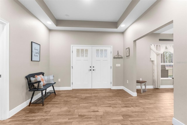 foyer entrance featuring light wood-type flooring and a tray ceiling