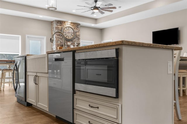 kitchen featuring ceiling fan, stainless steel refrigerator, and light hardwood / wood-style floors