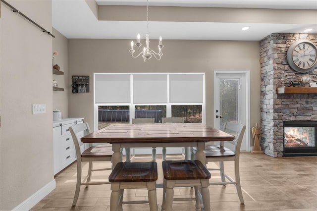 tiled dining room featuring an inviting chandelier and a fireplace