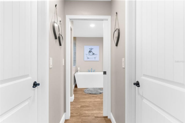 hallway with light hardwood / wood-style floors