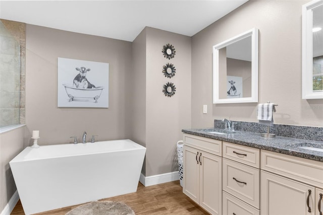 bathroom with vanity, hardwood / wood-style floors, and a tub