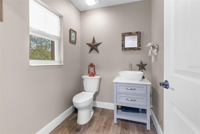 bathroom with hardwood / wood-style flooring, vanity, and toilet