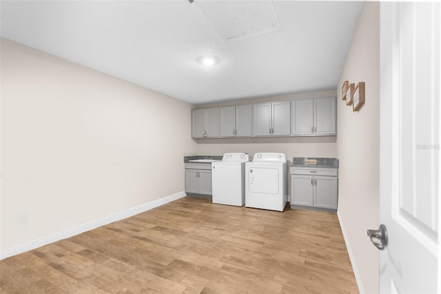 laundry room with cabinets, light hardwood / wood-style flooring, and independent washer and dryer