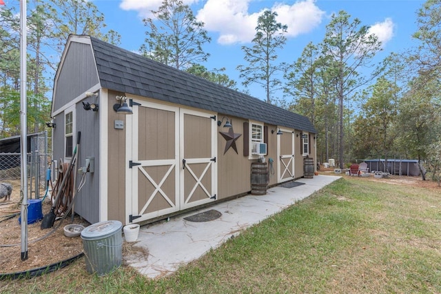 view of outdoor structure featuring cooling unit and a lawn