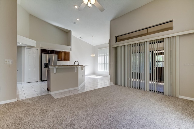 interior space featuring ceiling fan, light carpet, and high vaulted ceiling