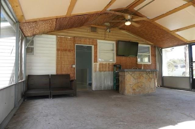 exterior space featuring ceiling fan and vaulted ceiling