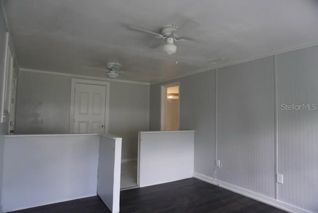 empty room featuring ceiling fan, dark hardwood / wood-style floors, and crown molding