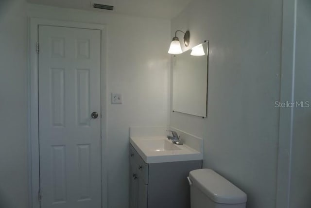 bathroom featuring toilet and vanity