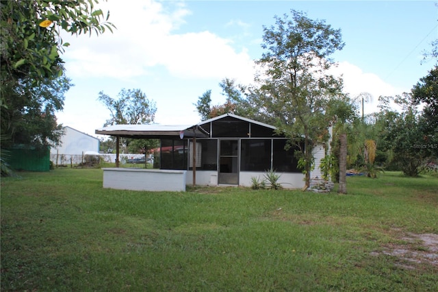 back of property featuring a lawn and a sunroom