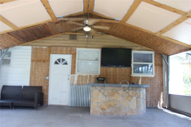 exterior space with concrete flooring, vaulted ceiling with beams, and ceiling fan