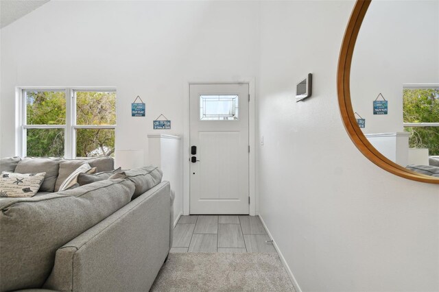 entryway with light hardwood / wood-style floors and lofted ceiling