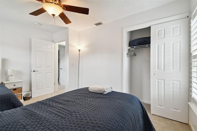 carpeted bedroom with a textured ceiling, a closet, multiple windows, and ceiling fan