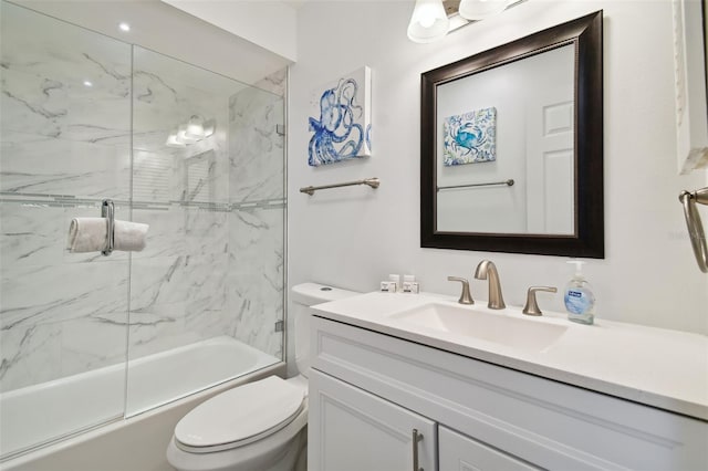 full bathroom featuring vanity, bath / shower combo with glass door, and toilet