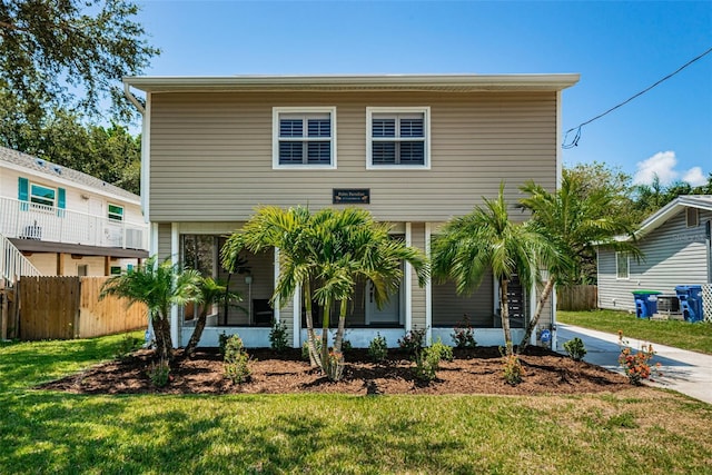 view of front facade with a front yard and a sunroom