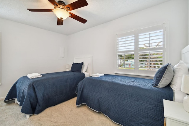 carpeted bedroom with ceiling fan and a textured ceiling