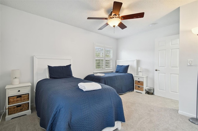 carpeted bedroom with ceiling fan and a textured ceiling