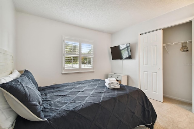 carpeted bedroom with a closet and a textured ceiling