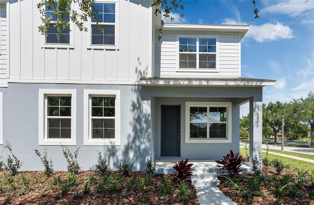 view of front facade with board and batten siding and stucco siding