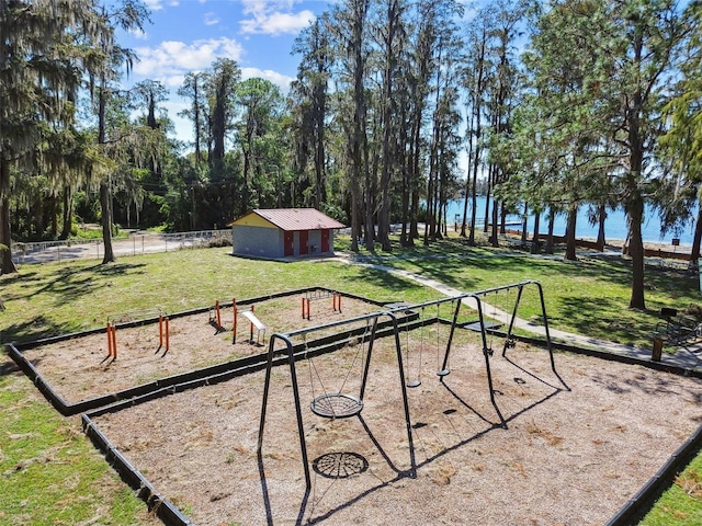 view of yard featuring a playground, a water view, and an outdoor structure