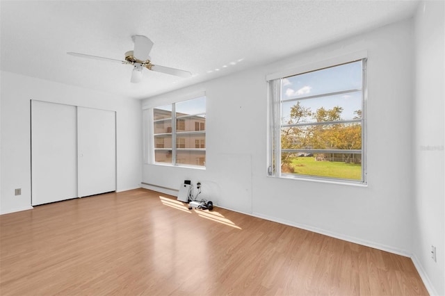 unfurnished bedroom featuring a closet, ceiling fan, a textured ceiling, and light hardwood / wood-style floors