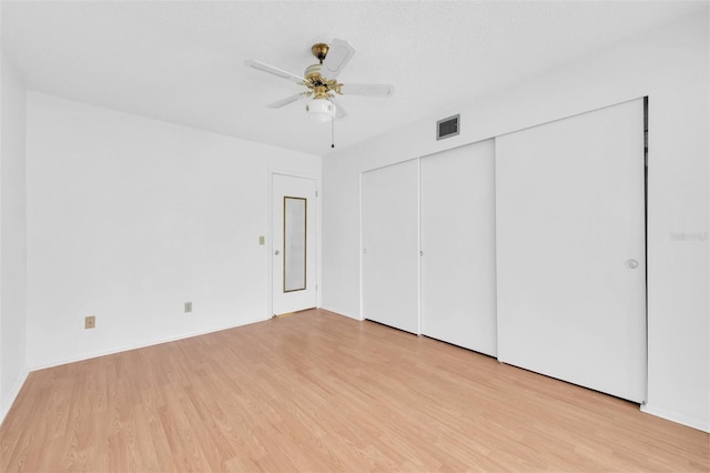 unfurnished bedroom featuring a textured ceiling, light hardwood / wood-style floors, and ceiling fan