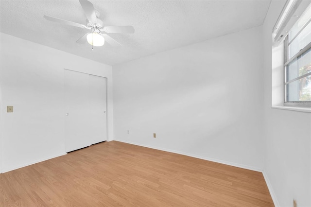 empty room with light hardwood / wood-style flooring, a textured ceiling, and ceiling fan