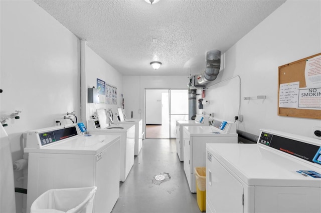 clothes washing area featuring a textured ceiling and washing machine and clothes dryer