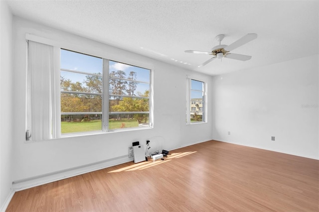 empty room with hardwood / wood-style floors, a textured ceiling, and ceiling fan