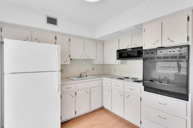 kitchen featuring sink, black appliances, white cabinetry, and light wood-type flooring