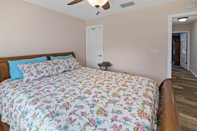 bedroom with dark hardwood / wood-style flooring and ceiling fan