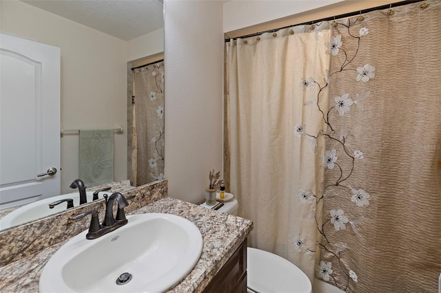 bathroom featuring vanity, toilet, a textured ceiling, and curtained shower