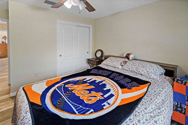 bedroom featuring ceiling fan, a closet, and wood-type flooring