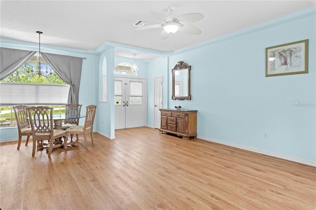 dining area featuring light hardwood / wood-style floors and ceiling fan with notable chandelier