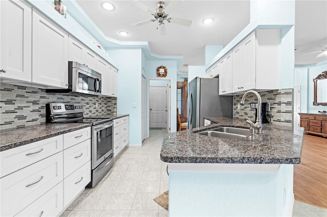 kitchen with stainless steel appliances, backsplash, ornamental molding, sink, and white cabinetry