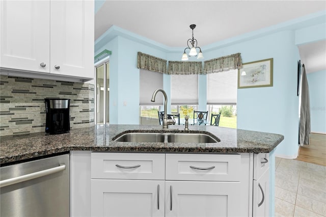 kitchen with tasteful backsplash, sink, dishwasher, dark stone counters, and white cabinets