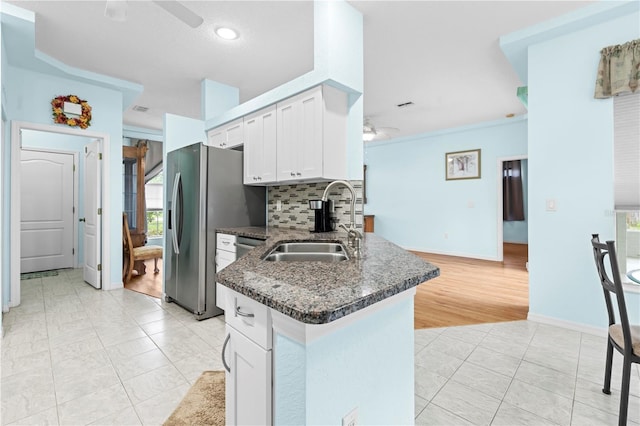 kitchen with white cabinets, tasteful backsplash, ceiling fan, light hardwood / wood-style flooring, and sink