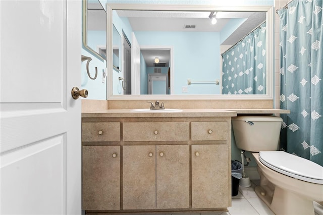 bathroom featuring toilet, vanity, and tile patterned floors