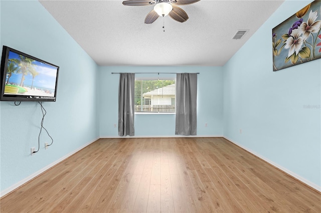 empty room featuring light hardwood / wood-style floors, a textured ceiling, and ceiling fan